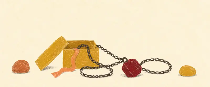 Birthstone gift ideas: a garnet pendant spilling from an open gift box, its chain pooled beside two tumbled stones